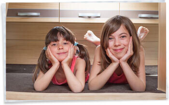 2 Kids lying on a bunk bed inside a touring caravan